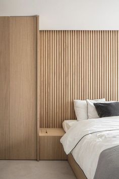 a bed sitting next to a wooden wall in a bedroom