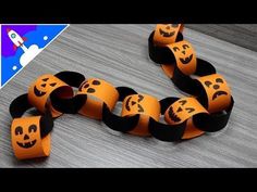 an orange and black paper chain with faces on it