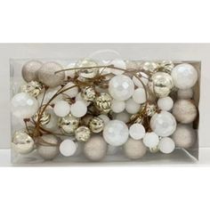 white and silver ornaments in a clear box