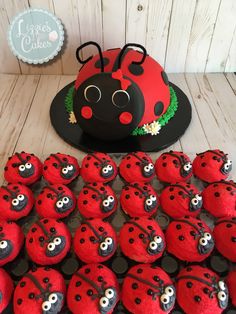 a table topped with lots of red cupcakes covered in ladybug decorations