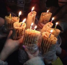 several people holding candles in their hands