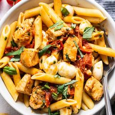 a white bowl filled with pasta and chicken