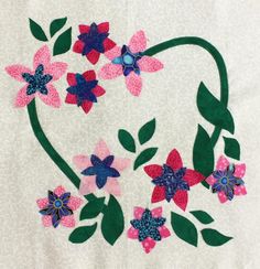 a close up of a piece of cloth with flowers and leaves in the shape of a heart