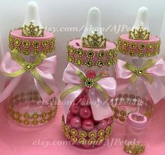 three pink and gold decorated bottles with bows on them are sitting next to each other