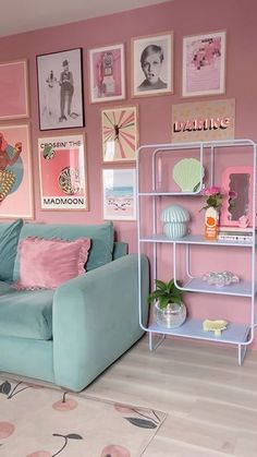 a living room with pink walls and blue couches in front of pictures on the wall