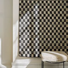 a black and white checkered wall hanging next to a chair