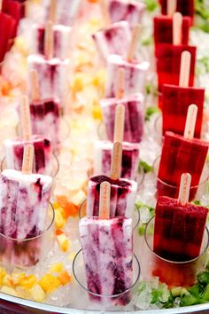 several popsicles are lined up on ice with fruit and vegetables in the trays