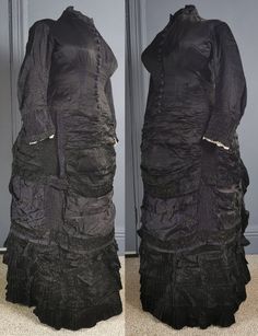 A superb, gothic Victorian antique bustle dress for mourning, dating to the early 1880s / natural form era - excellent condition, and a rare larger size. One piece, in a glossy two tone silk, black, the reverse in purple, the dress reflecting subtle purple tones. Closely fitted to the body, the bodice boned, fastening in the front with woven dome buttons in purple from neck to hip. Small collar, and a small waist patch pocket. Long fitted sleeves, with gathered cuffs and lace trim on the inner e Black Victorian Dress With Long Sleeves, Black Long Sleeve Victorian Dress, Black Victorian Gothic Dress With Historical Design, Black Gothic Victorian Dress With Historical Design, Black Victorian Dress Costume, Black Victorian Dress For Costume, Black Victorian Dress With Ruffles, Black Victorian Dress For Theater, Fitted Historical Victorian Dress For Larp