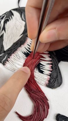 someone is working on something with scissors and thread