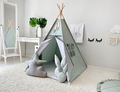 a child's teepee tent sitting on top of a white rug