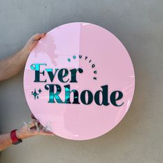 a person holding up a pink sign that says ever rnode