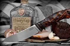 a large knife sitting on top of a cutting board next to some meat and vegetables