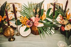 the table is decorated with tropical flowers and candles