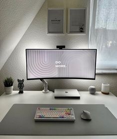 a computer monitor sitting on top of a desk next to a keyboard and mouse pad