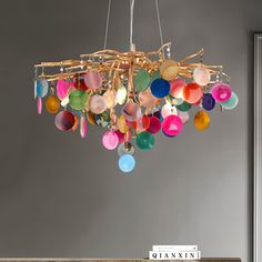 a chandelier hanging from the ceiling with many colorful glass balls on it's chain