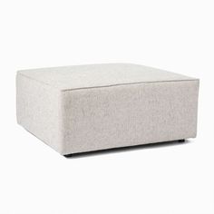 a large square ottoman sitting on top of a white floor