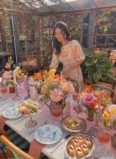 a woman standing in front of a table filled with food