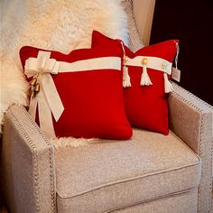 two red and white pillows sitting on top of a chair