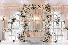 a white couch sitting under a floral arch