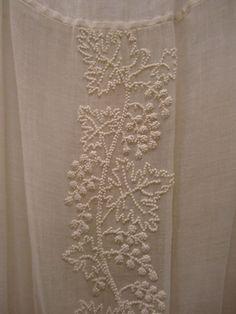 an embroidered curtain with white beads on it