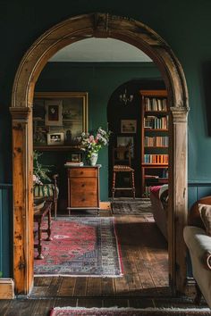 an archway leading into a living room with bookshelves and furniture in the background