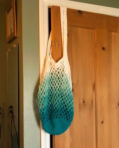 a crocheted bag hanging from a hook on a door