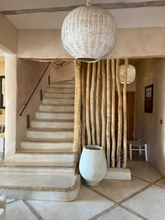 a large white vase sitting in front of a set of stairs next to a staircase