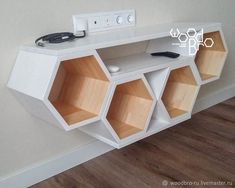 a white shelf with several cubbys on it and a phone plugged into the wall