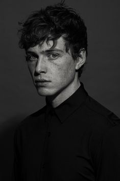 a black and white photo of a man with freckled hair looking at the camera