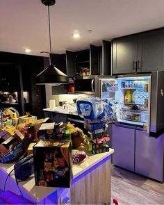 a kitchen filled with lots of food next to a refrigerator freezer and counter top