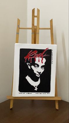 an easel with a black and red painting on it