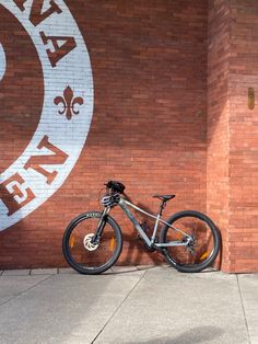 a bike is parked in front of a brick wall with the word new orleans painted on it