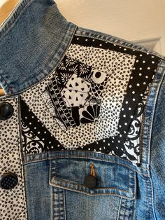 a denim jacket with black and white designs on it