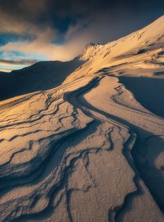 a snow covered mountain with tracks in the snow