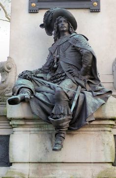 a statue of a man sitting on top of a stone slab