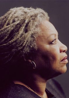 a black and white photo of a woman with dreadlocks looking off to the side