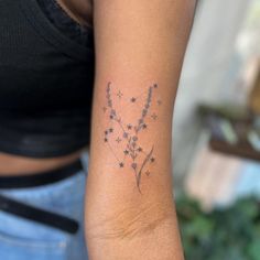 a woman with a tattoo on her arm has a star and flower design on it