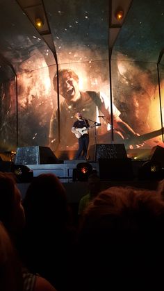 a man standing on top of a stage next to a giant screen with an image of a gorilla