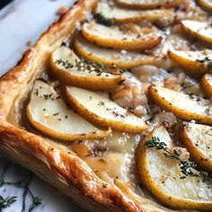 a baked dish with potatoes and herbs on top