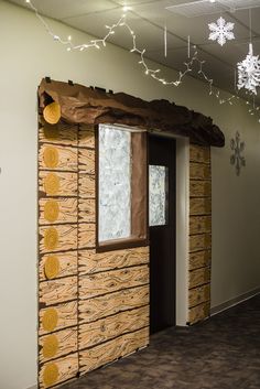 a room that has been made to look like a log cabin with snowflakes hanging from the ceiling