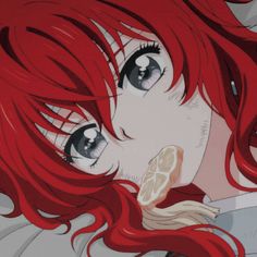 a woman with red hair and black eyes is staring into the distance while holding a lemon slice in her hand