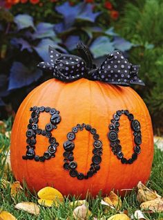 an orange pumpkin with the word diy spelled out on it in black beads and a bow