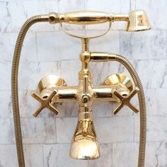 an old fashioned brass faucet in the shape of a cross on a marble wall