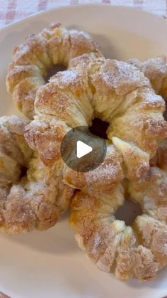 a white plate topped with donuts on top of a checkered tablecloth covered table