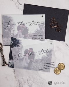 wedding save the date cards and key on a marble table