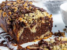 a close up of a cake on a plate with chocolate drizzle and crumbs