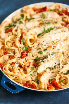 a skillet filled with pasta and chicken covered in sauce