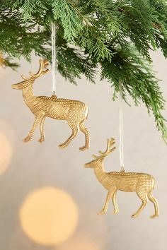 two gold deer ornaments hanging from a christmas tree