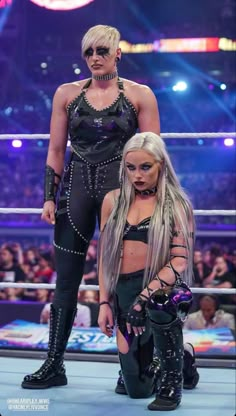 two women standing next to each other on a wrestling ring