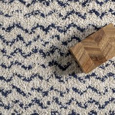 a piece of wood sitting on top of a blue and white rug